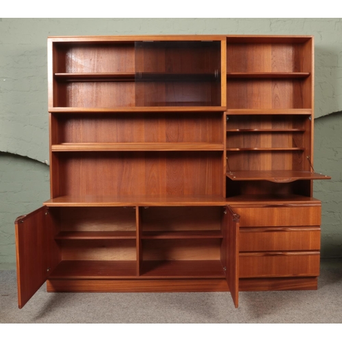 586 - A McIntosh two-tier teak wall unit, with glass sliding doors, shelving, drawers and cupboard drawers... 