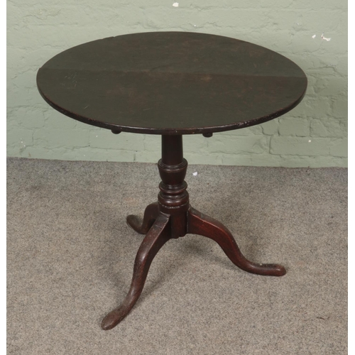 591 - An oak tilt top table on three cabriole legs. Approx. table diameter 75cm.