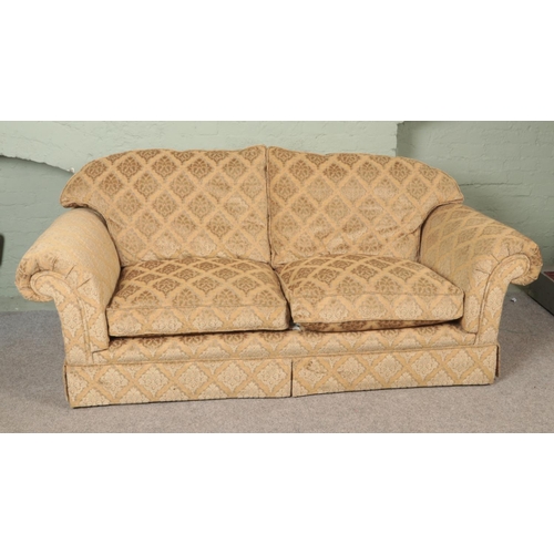 603 - A three seat sofa with beige floral upholstery. Length: 224cm.