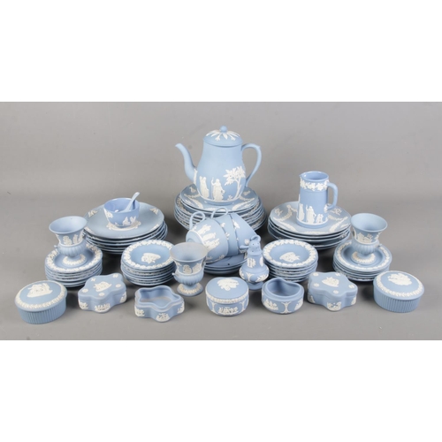 127 - A large collection of Wedgwood blue Jasperware. Includes teapot, Christmas year plates, trinket dish... 