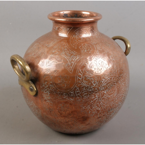 147 - An Eastern copper vessel with engraved decoration. (23cm)