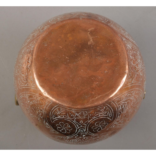 147 - An Eastern copper vessel with engraved decoration. (23cm)