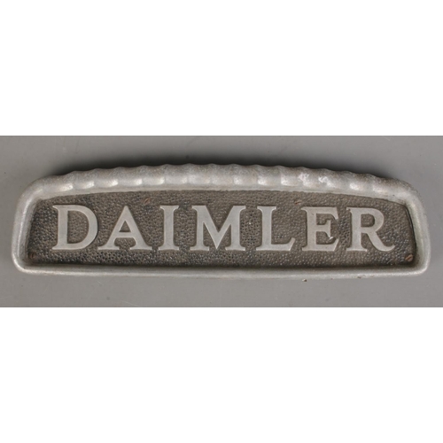 178 - A vintage cast metal Daimler car badge. (11cm x 38.5cm)