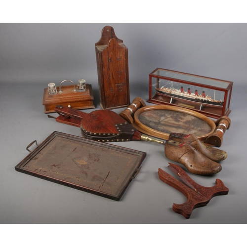 191 - A box of woodenwares. Includes wall hanging candle box, trays, desk stand, ship in display case, etc... 