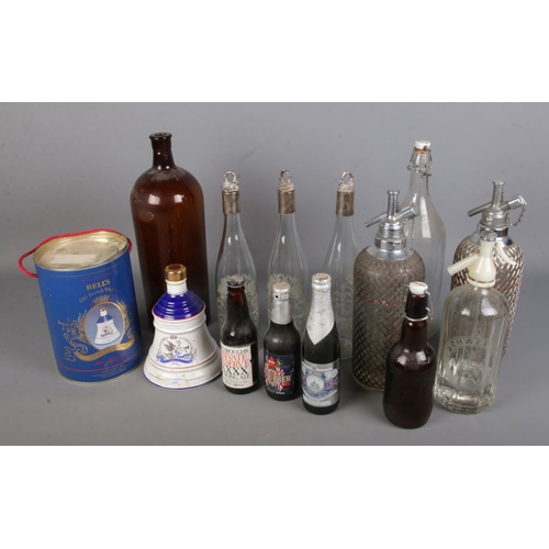 194 - A box of alcohol related items. Includes boxed full & sealed Bell's whiskey decanter, large glass bo... 