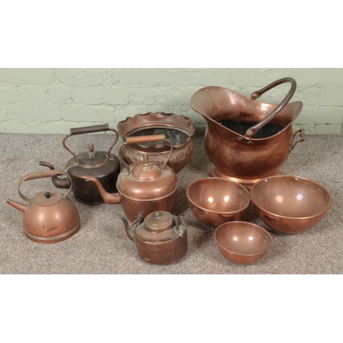 196 - A good collection of copper wares to include coal scuttle, several teapots, graduated bowls, etc.