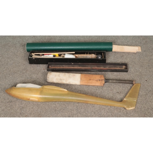 234 - A fiberglass glider shell along with model plane building kit, spare balsa wood and cricket bat.