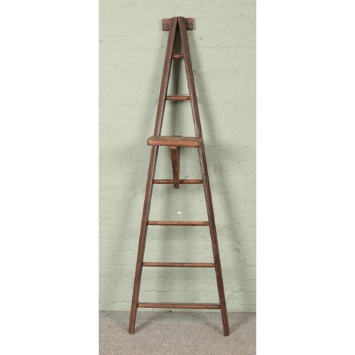 302 - A seven rung wooden A-Frame ladder, possibly for fruit picking, with a platform step. Height: 191cm.