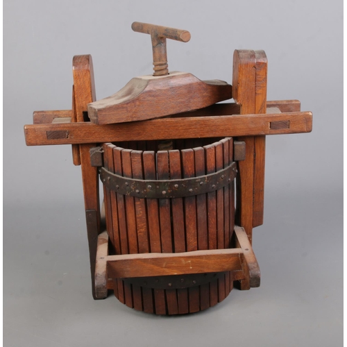 316 - A small cast iron and wooden fruit press. Approx. dimensions 42cm x 41cm.