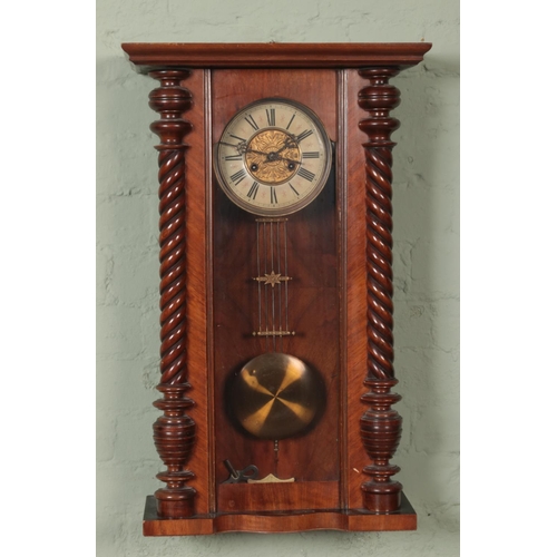 379 - A mahogany Vienna style wall clock featuring roman numeral dial.