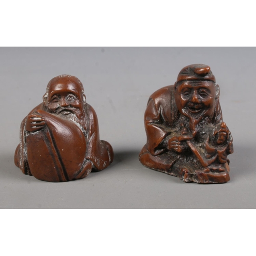 403 - Two Japanese carved hardwood netsukes formed as a gentleman crafting a doll and a gentleman holding ... 