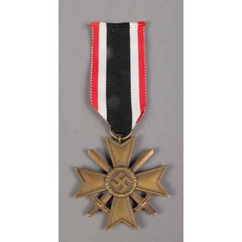 405 - A Nazi Merit Cross on striped ribbon. With crossed swords and dated 1939 to the back.