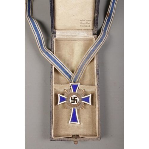 406 - A German Third Reich 'Cross of Honour of the German Mother' medal in fitted case. With enamelled blu... 