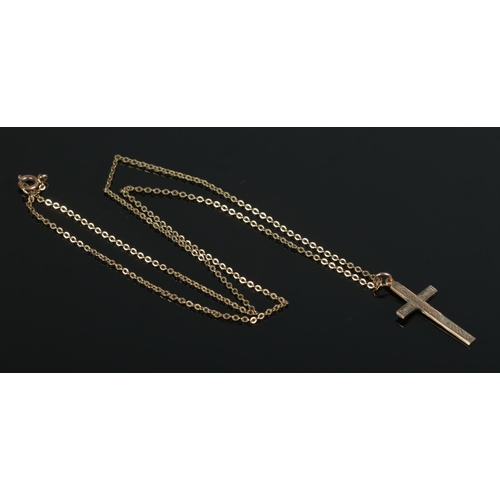 429 - A 9ct Gold crucifix pendant, on yellow metal chain. Weight of pendant: 1.1g.