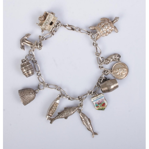 437 - A vintage silver charm bracelet featuring eleven charms including turtle, barrels, fish, boat, etc. ... 