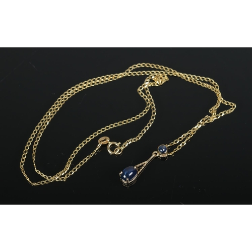 449 - A 9ct gold and sapphire pendant on chain set with two cabochon stones. Total weight 2.1g.