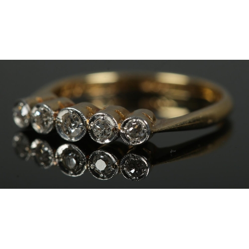 452 - An 18ct gold and platinum ring set with five diamonds. Size M, 2.4g.