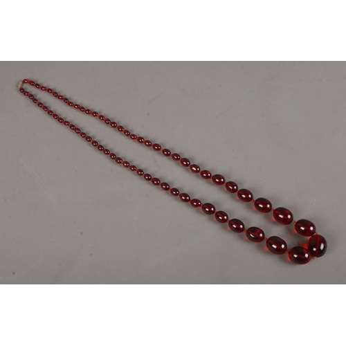 473 - A string of cherry red bakelite graduated beads. Total weight 85.4g. Approx. length when clasped 49c... 