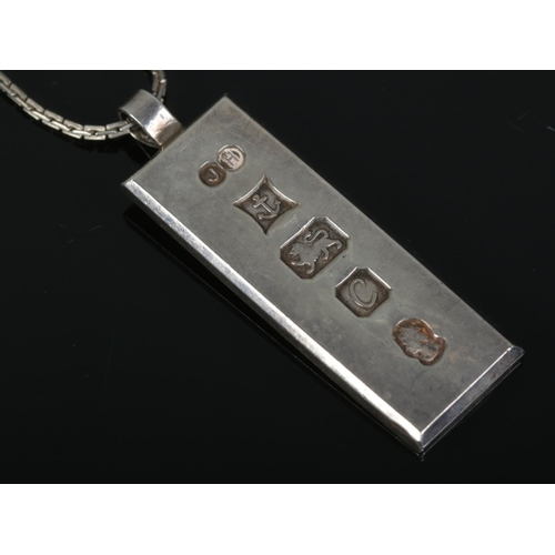 480 - A silver ingot on white metal chain. Ingot assayed for Birmingham, 1977 by James Harrison. Total wei... 