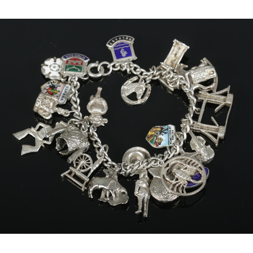 483 - A silver charm bracelet containing a large collection of Sterling Silver, Continental Silver and whi... 