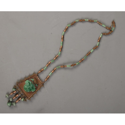 486 - A Mexican carved jade and gilt metal necklace and pendant.