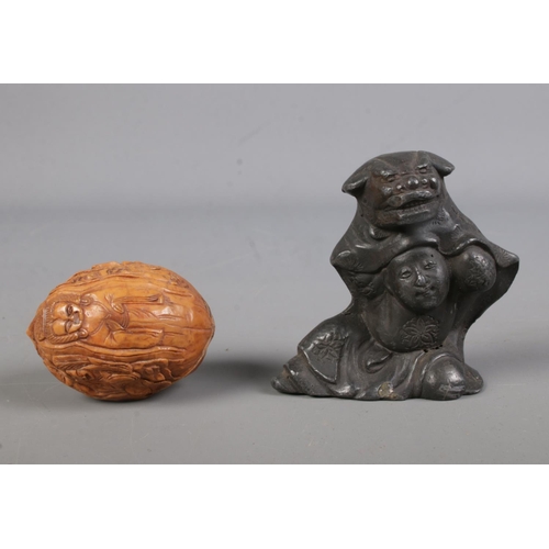 491 - A large metal netsuke, possibly pewter, formed as a gentlemen wearing dog of foo cloak along with an... 