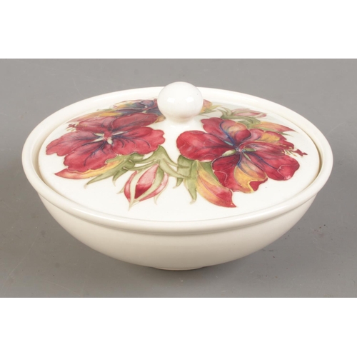 512 - A Moorcroft pottery lidded bowl decorated in the Hibiscus pattern. Diameter 17cm.