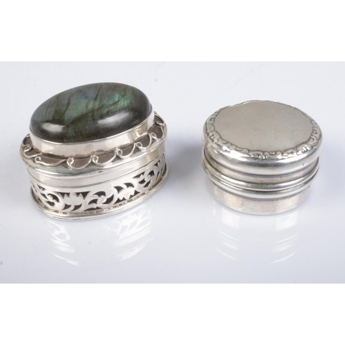 515 - Two silver pill boxes; one pierced floral and scrolled detailing and mounted with large polished har... 