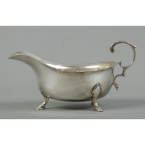 518 - An early Twentieth Century silver cream jug, with frilled edge and raised on three hoof feet. Assaye... 