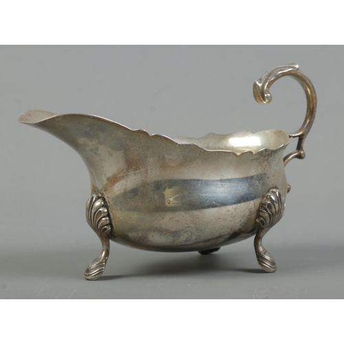 520 - A George VI silver sauceboat, raised on three shell and hoof feet. Assayed London, 1939 by Edward Ba... 