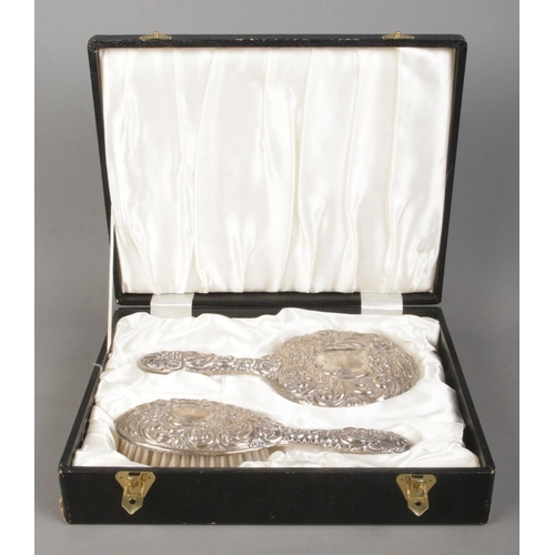 525 - A cased Gents two piece silver filled dressing table set, containing handheld mirror and brush, both... 