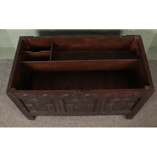 535 - An 18th century oak joined coffer with hinged top and profusely carved tri panel base fitted with in... 