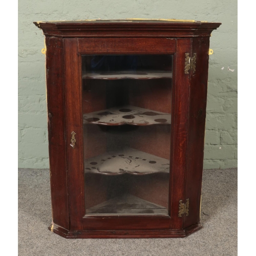 549 - A Georgian oak hanging corner cabinet with single glazed door.

Hx82cm
Wx67cm
Dx40cm