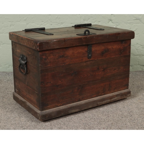 551 - A pine trunk with hasp lock lid and cast iron handles.

Hx44cm
Wx64cm
Dx37cm