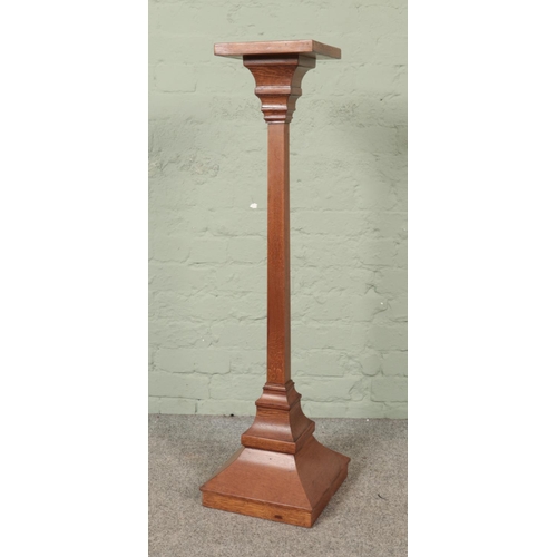 552 - An oak torchere with square top over a plain square column on a stepped base.

Hx110cm