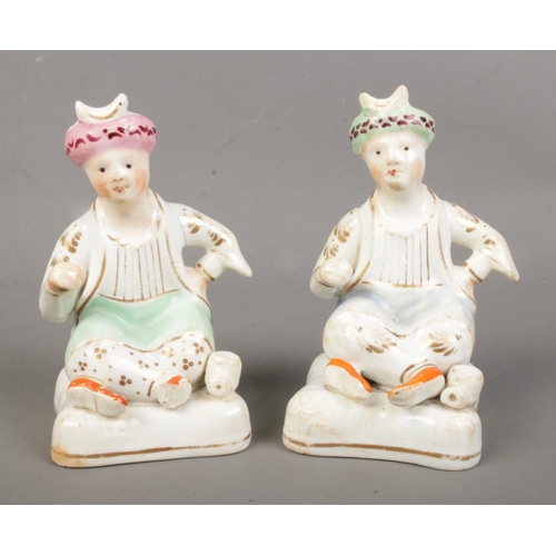 97 - Two 19th century Staffordshire Lloyd Shelton type figures, each modelled as a seated Turk, decorated... 