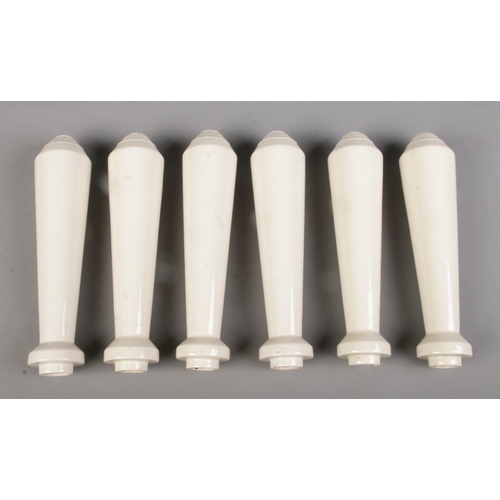 103 - A set of six ceramic beer pump handles. 23cm long.