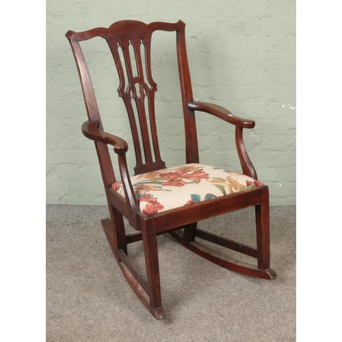 602 - An oak rocking chair with upholstered drop seat.