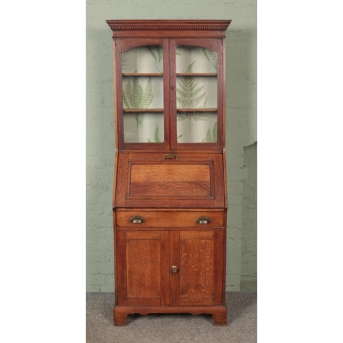 617 - An early 20th century oak bureau bookcase of slender proportions and brass cup handles.

Hx188cm
Wx6... 