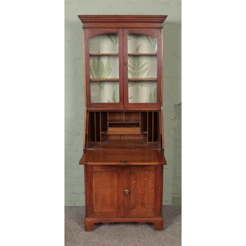 617 - An early 20th century oak bureau bookcase of slender proportions and brass cup handles.

Hx188cm
Wx6... 