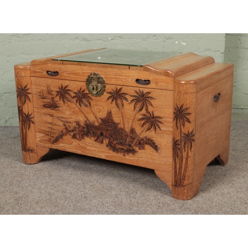 619 - An ornately carved blanket chest. With camphor lining and featuring glass covered shipping scene to ... 