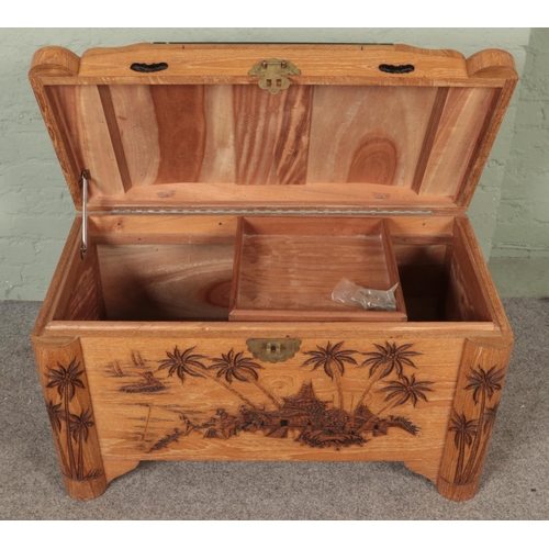 619 - An ornately carved blanket chest. With camphor lining and featuring glass covered shipping scene to ... 