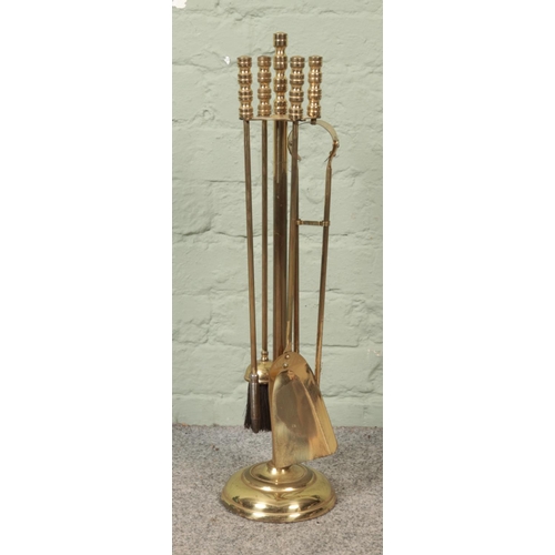 124 - A four piece brass fireside companion set.