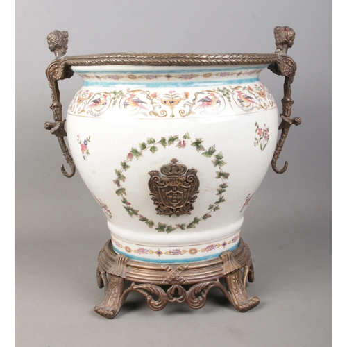 126 - A large Wong Lee 1895 ceramic planter urn, raised on circular metal stand with four paw feet and scr... 