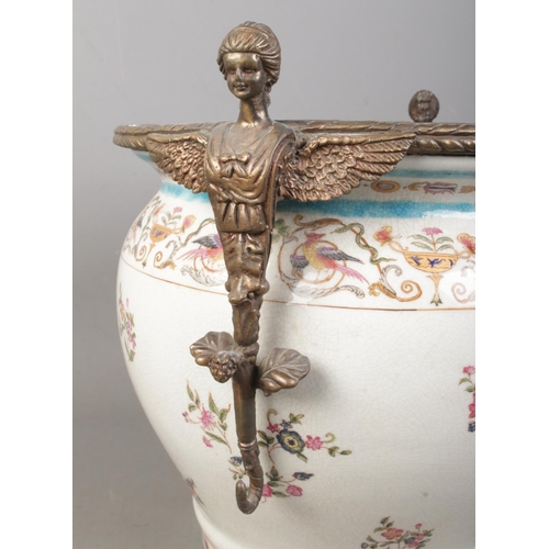 126 - A large Wong Lee 1895 ceramic planter urn, raised on circular metal stand with four paw feet and scr... 