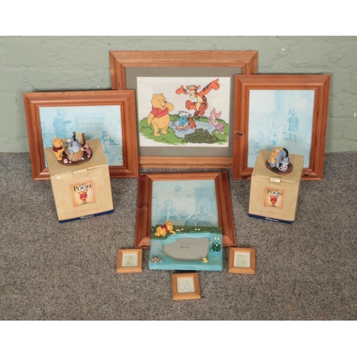 180 - A quantity of Winnie The Pooh collectables. Includes boxed figures, framed pictures, etc.