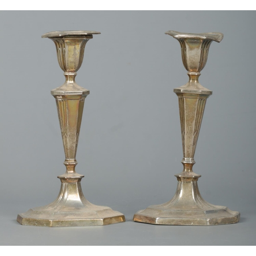 107 - A pair of early 20th century silver candlesticks, raised octagonal stepped bases. Assayed Sheffield ... 