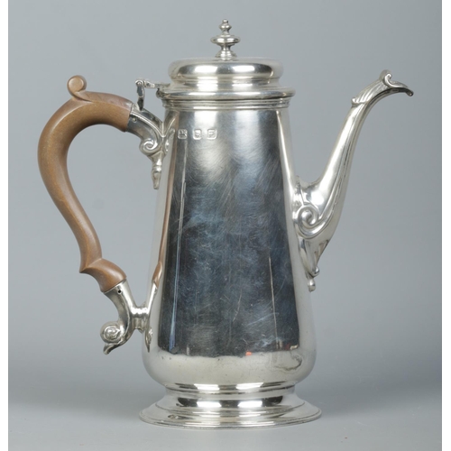 114 - A George VI silver hot water pot with urn shaped finial and wooden handle. Assayed London 1941 by Na... 