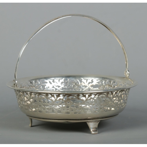 117 - A George V pierced silver swing handle basket raised on three feet. Assayed Birmingham 1915, possibl... 