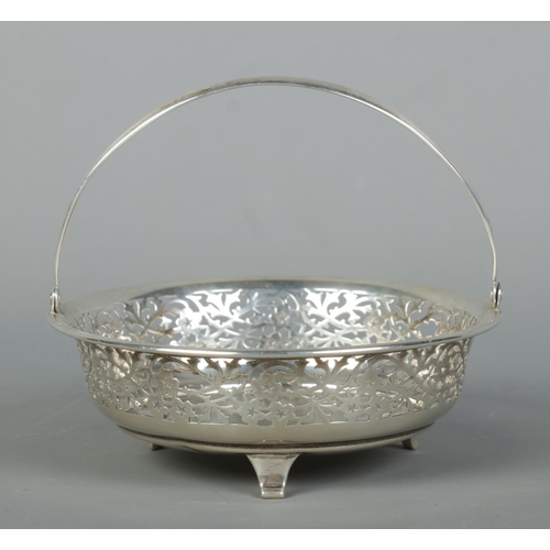 117 - A George V pierced silver swing handle basket raised on three feet. Assayed Birmingham 1915, possibl... 